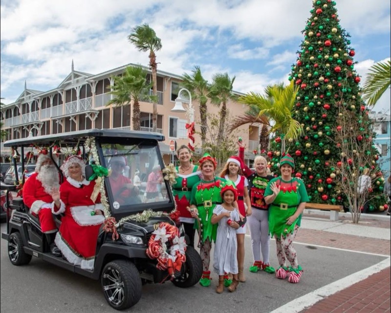 Santa and elves on a golf cart at holiday event